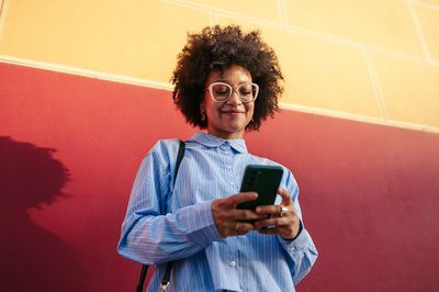 Eine Frau schaut entspannt auf ihr Smartphone.